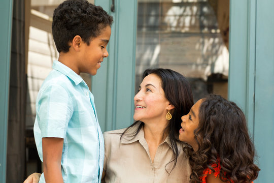 Happy Hispanic Mother Laughing And Talking With Her Children.