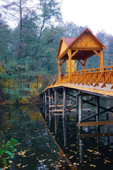 Wooden bridge over the river with a canopy. 