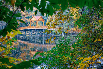 Wooden bridge over the river with a canopy. 