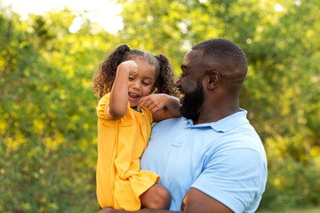 Father laughing and playing with his daugher.
