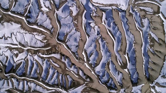 Aerial view of desert terrain texture with the sun melting the snow creating an eroded landscape in the Utah Badlands.
