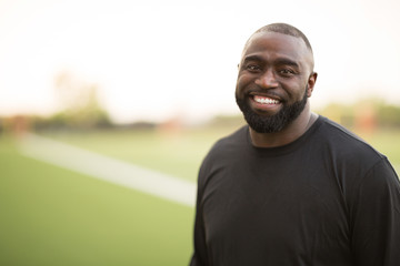 Portrait of an African American Football coach smiling.