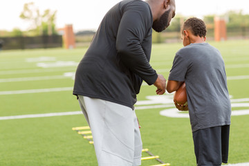 American Football coach training a young athlete.