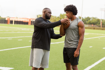 American Football coach training a young athlete.