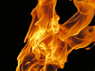 Blurred fire flame - abstract background. Bright red-yellow fiery texture of flames movement is an expressive design element of a dramatic, mystic or romantic theme.