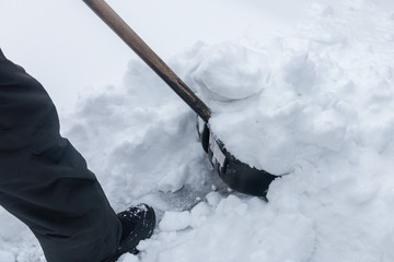 man cleans snow shovel