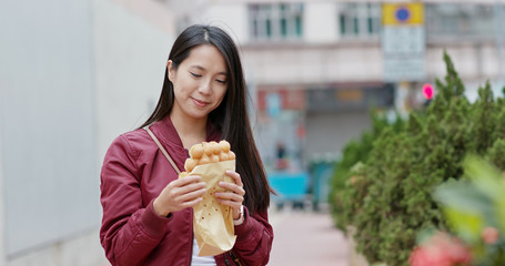 Woman eat local food, egg waffle in Hong Kong