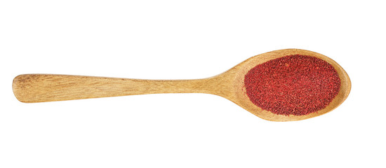 Ground sumac spice powder in wooden spoon isolated on white background. Top view. Flat lay