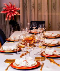 Festive table decorated with gold colored plates and cutlery