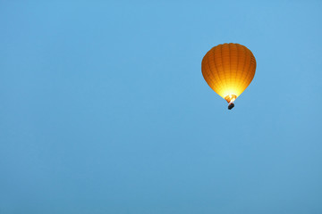 Travel. Yellow Hot Air Balloon With Fire Light Flying In Sky