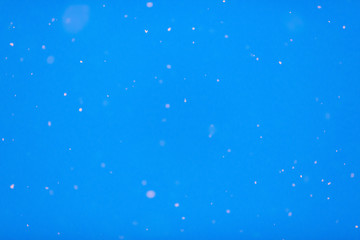 Winter background. Blue sky with falling snow, snowflake.