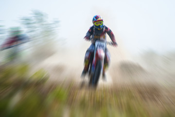 Blurry image of motorcycle riders during motocross race with zoom effect