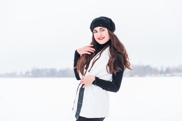 Fototapeta na wymiar Happy smiling woman Hispanic appearance with dark hair in knitted clothes at snowy winter day, good mood and holidays concept 