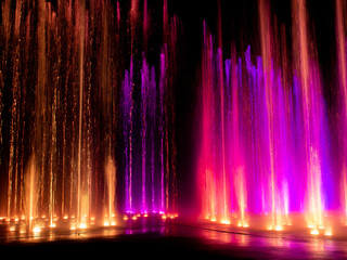  colored decorative dancing water jet led light fountain show at night - Powered by Adobe
