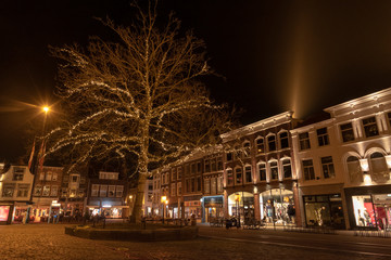 Fototapeta na wymiar The Gouda market in the evening with a lighted tree and houses with old facades. The Netherlands, Europe.