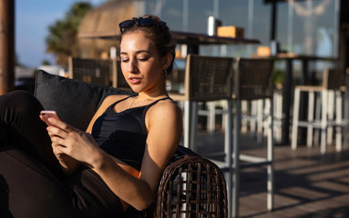 Young woman enjoys mobile phone in a bar