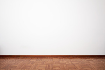 Empty room with brown wooden tiled floor and white blank wall