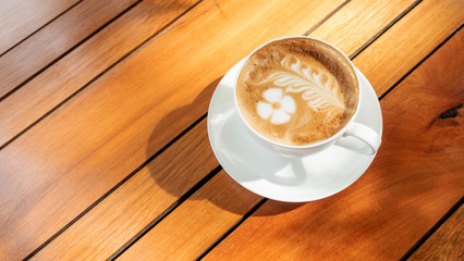 Hot latte coffee on a wooden table.