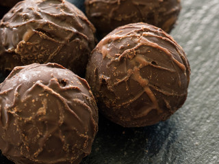 Runde Schokoladenpralinen auf einer Schieferplatte