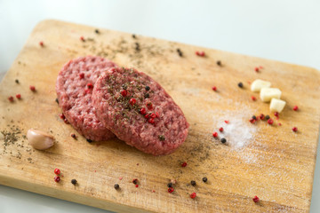 raw pork steaks with spices on wooden Board