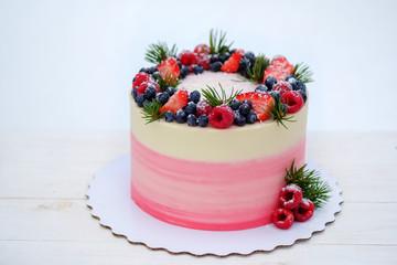 beautiful birthday cake in winter style with fir branches and natural berries