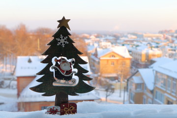 New Year and Christmas wooden  decorations against the backdrop of the winter cityscape.