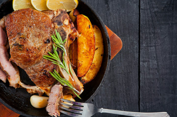 Grilled beef steak and baked potatoes in a cast iron pan