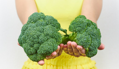 girl holding a green broccoli salad in her hands. extending your arms forward with .