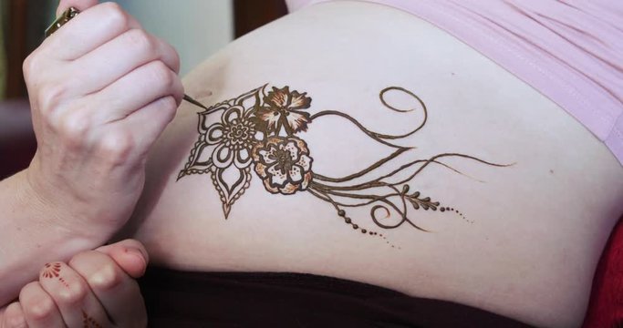 Drawing a mehendi on the stomach
