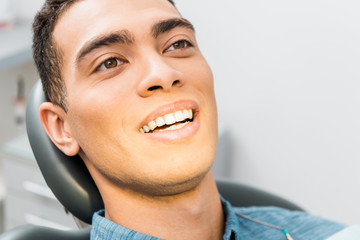 Obraz premium close up of smiling african american man in dental clinic
