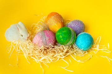 colorful, hand-painted, pastel Easter eggs on a bright, yellow, spring background