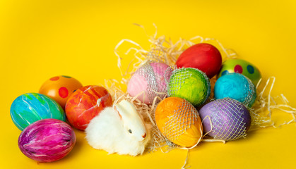 colorful, hand-painted, pastel Easter eggs on a bright, yellow, spring background