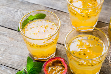 Passion fruit - Passion fruits half and juice with mint on the vintage wooden background.