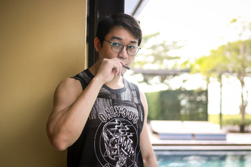 Asian man wearing glasses and smoking cigar