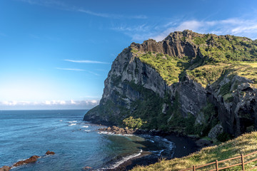 Fototapeta premium A huge rock mountain with green vegetation in the top in Jeju island in South Korea