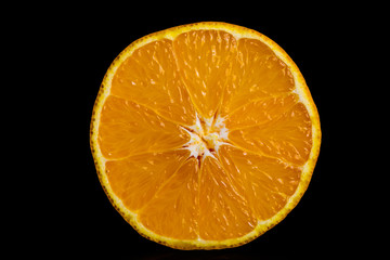 Halbierte Orange isoliert vor schwarzem Hintergrund