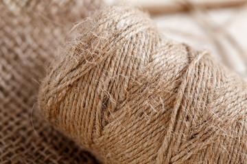 Coarse threads next to canvas on wooden vintage background.