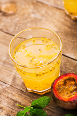 Glass of fresh passion fruit with mint on table