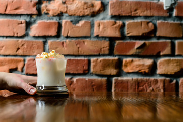 cocktail in guest's hand in a bar close up, visitor with a cocktail behind the bar