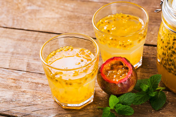 Passion fruit - Passion fruits half and juice with mint on the vintage wooden background.