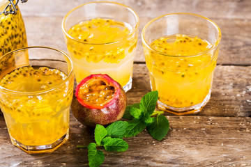 Passion fruit - Passion fruits half and juice with mint on the vintage wooden background.