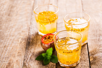 Passion fruit - Passion fruits half and juice with mint on the vintage wooden background.