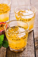 Passion fruit - Passion fruits half and juice with mint on the vintage wooden background.