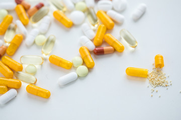 Gelbe und weiße Pillen Kapseln und Tabletten auf weißen Hintergrund