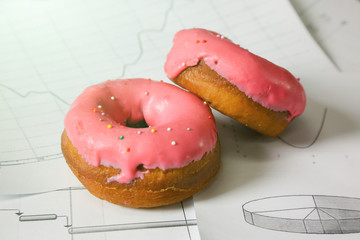 Two sweet cake in the workplace. Sweet breakfast on work papers in the office.