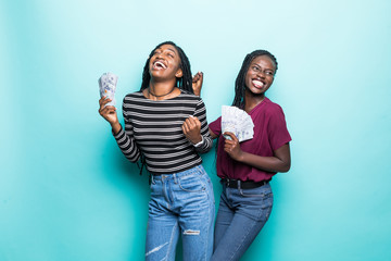 Photo of young african american womens win scream with dollar banknotes isolated over blue background