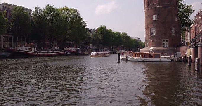 The famous &lsquo;Montelbaanstoren&rsquo; with The canal &lsquo;Oudeschans&rsquo; with authentic salon boats