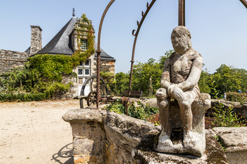Obraz premium Rochefort-en-Terre, France. A well with a statue at Rochefort, one of the most beautiful towns in Brittany (Bretagne)