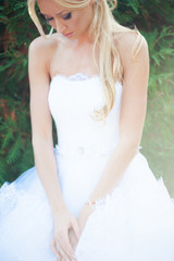 Fototapeta na wymiar Beautiful blonde bride in fashion white wedding dress