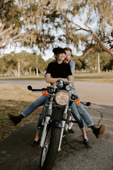 Obraz premium Precious Cute Leisure Lifestyle Portrait of Handsome Guy and Girl Beauty Being Silly Fun and Laughing while Riding Classic Motorcycle Bike While in Love